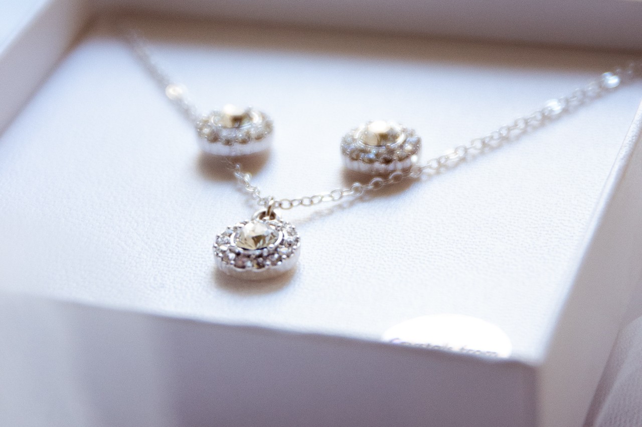 A close-up of a matching set of diamond earrings and a necklace, displayed in their box.