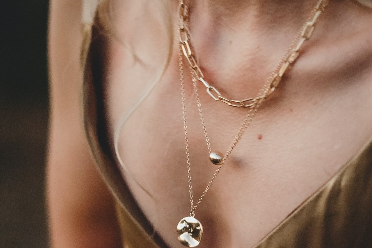 A woman wears multiple high-quality gold necklaces