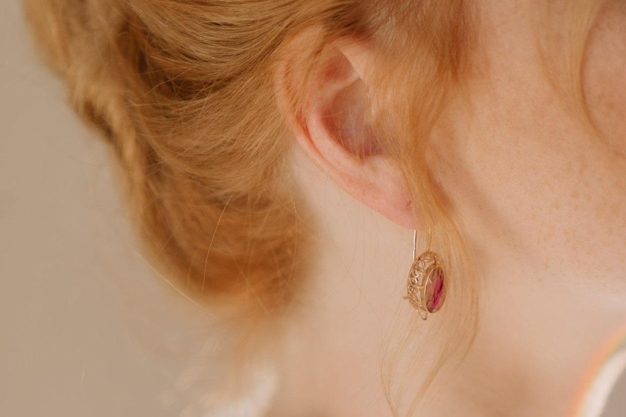 Close up image of a woman wearing a gold spinel earring