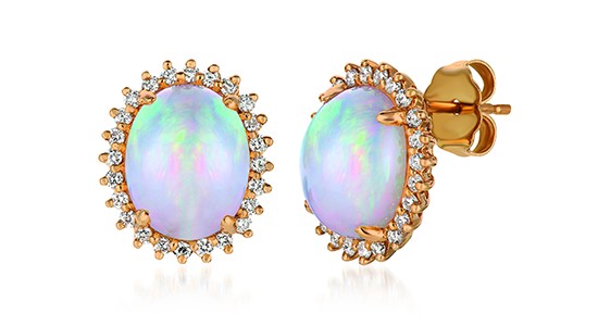 a pair of yellow gold stud earrings featuring oval opals surrounded by a halo of diamonds
