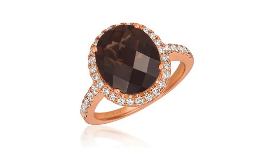a rose gold statement fashion ring featuring a brown, oval cut gemstone with diamond accent stones