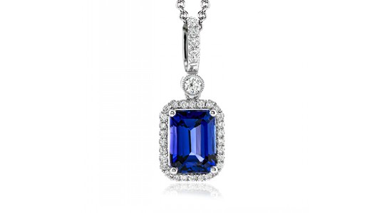 a white gold pendant necklace with diamond details, featuring an emerald cut tanzanite center stone