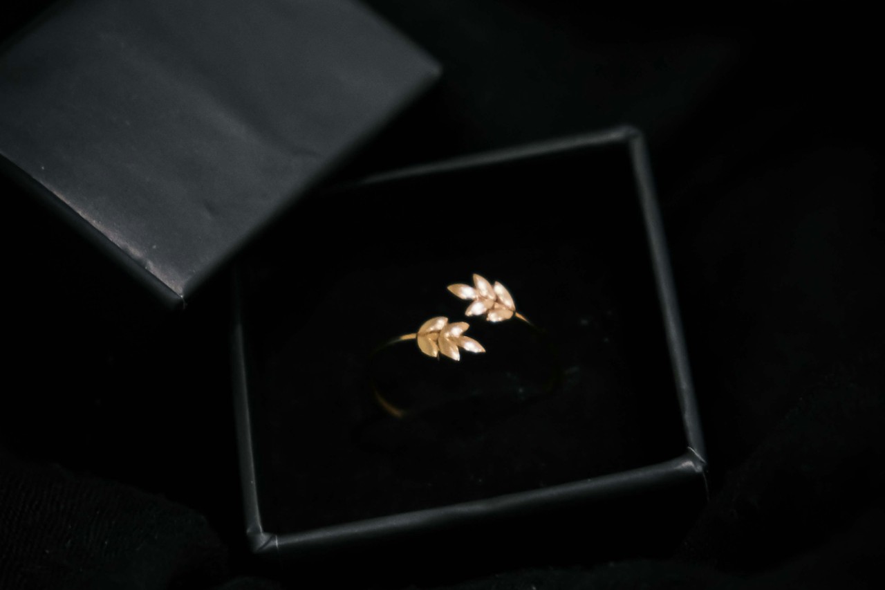 a leaf motif ring in a black jewelry gift box