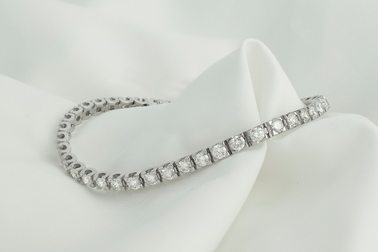 a white gold diamond line bracelet on a piece of white fabric