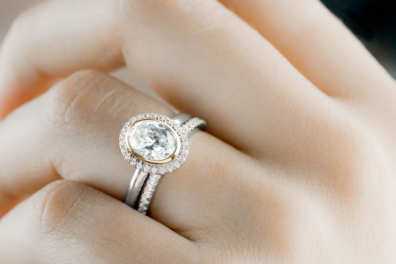 a Noam Carver diamond engagement ring worn with a wedding band