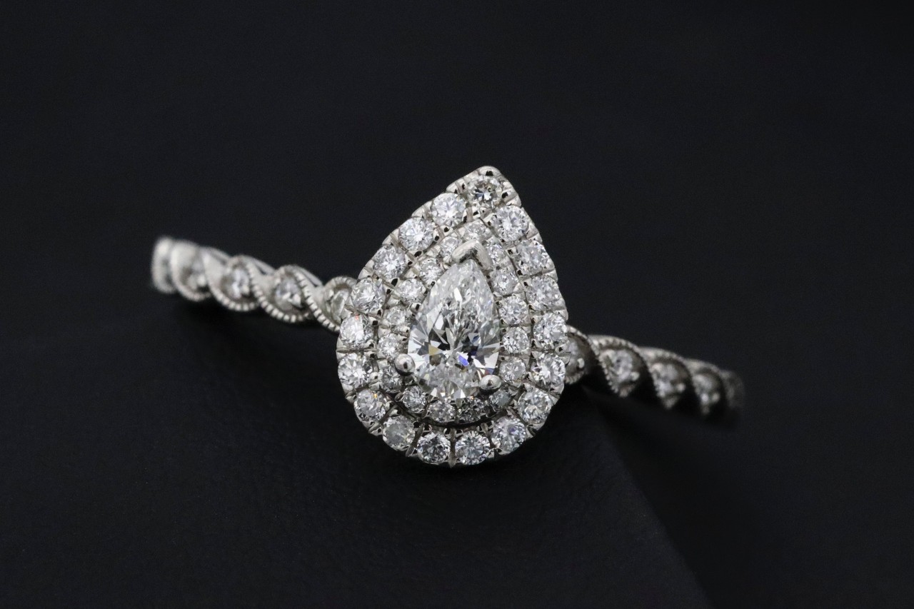 Engagement ring with pear cut diamond and enchanting halo setting