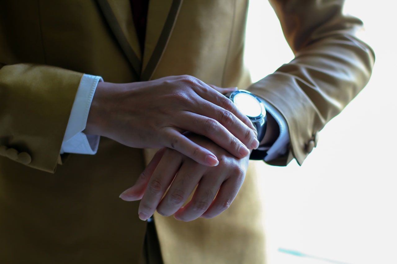 glare on timepiece on man in suit