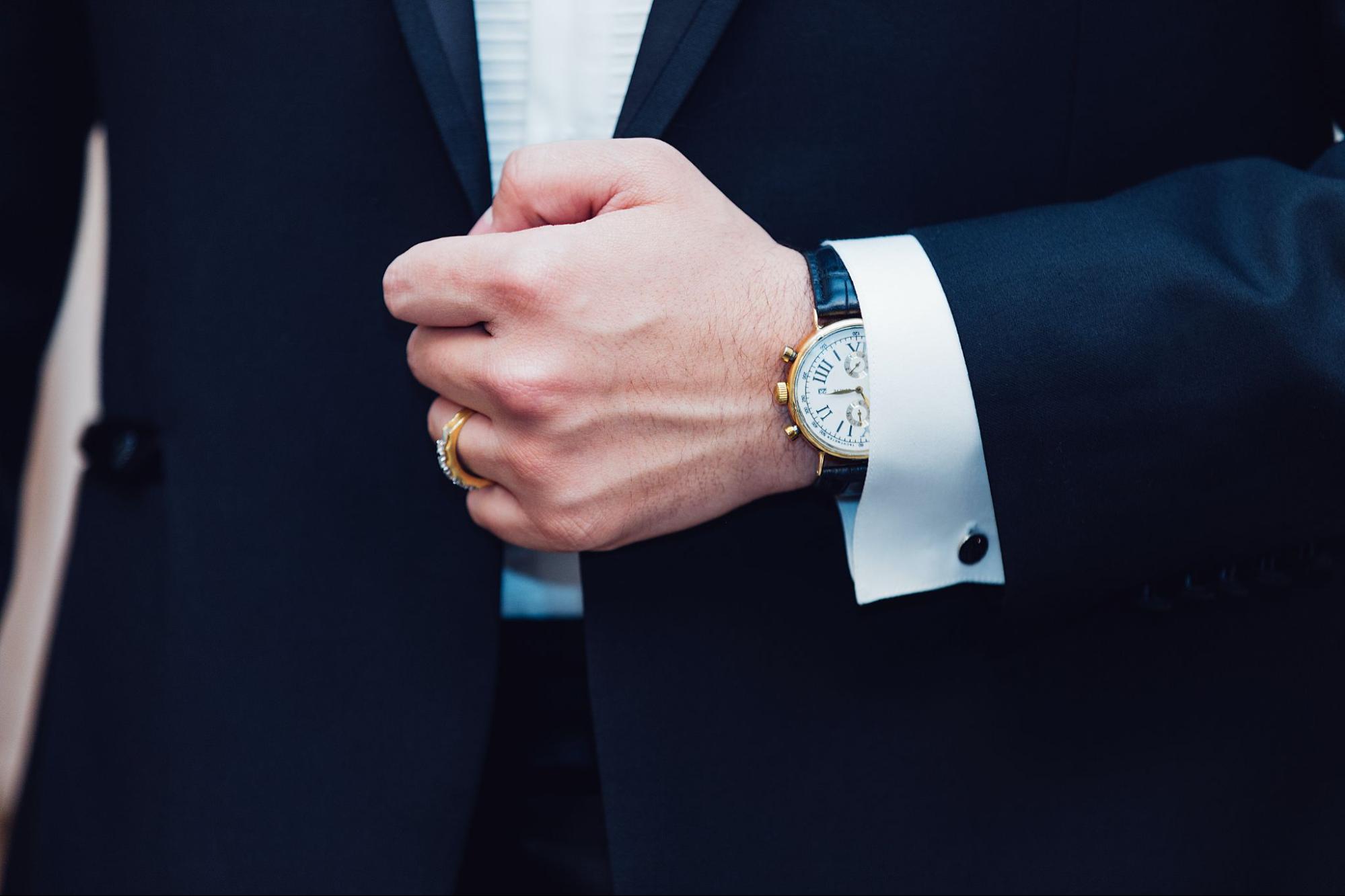 A man wearing a suit with a matching luxury watches